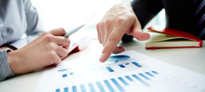 pointing at a sheet of graphs and charts